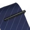 Gros plan d'une pince à cravate noire en métal élégante pour costume professionnel. - Noir