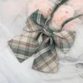 Detailed close-up of a Japanese JK style green and beige plaid bow tie with ribbons. - Green Beige Plaid
