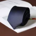 Detail shot of a classic dark blue striped necktie rolled neatly on a stylish background. - Hand-Tied / 8cm / Sea Breeze Blue