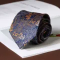 Detailed view of a classic blue paisley necktie, perfect for formal business and wedding suit styling. - Royal Paisley Hand-Tied / 8cm / Navy Blue