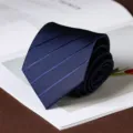 Detailed view of a classic dark blue striped necktie, perfect for business and formal wear. - Dark Pattern Hand-Tied Style / 8cm / Blue