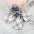Close-up detail of a sweet JK style plaid bow tie ribbon collar accessory with lovely pattern. - White Neon Plaid