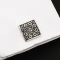 Gros plan détaillé sur les boutons de manchette carrés à motif rétro sur une manchette blanche. - Motif Classique