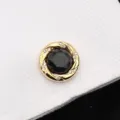 Gros plan détail de manchette dorée de luxe avec pierre scintillante noire et strass brillants. - Ciel Étoilé Vaste Or