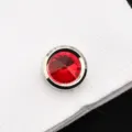 Vue de détail d'un bouton de manchette en cristal rouge étincelant sur chemise blanche. - Zircon Rouge