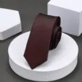 Close-up of a burgundy narrow necktie with fine twill texture displayed on white podiums. - 6cm Elegant Burgundy