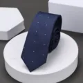 Primer plano de corbata estrecha azul oscuro con textura geométrica sutil y puntos blancos. - 6cm Punto Blanco de Onda