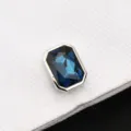 Gros plan détaillé d'un bouton de manchette élégant en cristal bleu avec monture argentée. - Grand Cristal Bleu