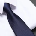Close-up detail of a dark blue textured men's business necktie paired with a crisp white shirt. - 8cm Navy Small Grid Dots Zipper Tie