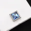 Détail en gros plan d'un bouton de manchette carré en cristal bleu pour homme élégant. - Bleu Cristal