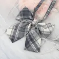 Close-up detail of a classic Japanese JK uniform plaid bow tie ribbon collar accessory. - Black White Gray Plaid