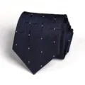 Dark blue geometric patterned necktie detail view for professional business wear. - Wave White Dot