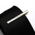 Detailed close-up of a golden tie clip with sparkling rhinestone on textured black fabric - Tie Clip Model C (Gift Box) / Gold