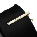Detailed close-up of a sleek gold metal tie clip featuring elegant engraved geometric stripe designs. - Tie Clip Model F (Gift Box) / Gold
