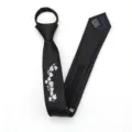 Vista detallada de una corbata negra con cremallera y elegante bordado floral blanco fino. - Estilo Cremallera Bordado Magnolia Blanca / 5cm / Negro