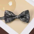 Close-up of mens vintage jacquard bow tie, black and gold textured fabric, suit accessory. - Stardust Undercurrent Bow Tie