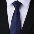 Detailed close-up shot of a classic dark blue striped necktie with white shirt and suit. - Blue Bold Stripe