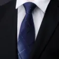 Close-up detail of a classic blue plaid mens necktie with elegant diagonal pattern. - Gentleman Plaid