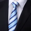 Close up detail of blue and white striped formal necktie displayed on shirt and suit. - Stylish Blue Stripe