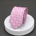 Close-up of pink patterned men's tie, intricate geometric floral jacquard detail texture. - H-14