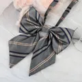 Detailed close-up of a stylish JK uniform bow tie with classic striped herringbone pattern. - Gray Gold Trim Ribbon Bow
