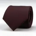 Detailed view of a dark red textured men's necktie, rolled up neatly, elegant formal wear. - Elegant Burgundy Striped Style / 8cm Wide / Burgundy