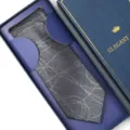 Detailed view of a classy grey patterned necktie neatly packed inside a dark blue premium gift box. - Zipper Style / Long Box / Grey Coiled Pattern