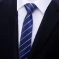 Detailed view of the slim blue striped necktie, perfect for business and casual wear. - Blue