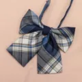 Close-up view of the blue and white plaid JK uniform bow tie, showing fine woven fabric texture. - Meie Plaid