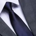 Detailed close-up of a classic dark blue business tie paired with a crisp white shirt. - Navy Glossy Zipper Style / 8cm