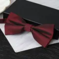 Detail view of a burgundy and black double-layer bow tie for formal suit wear. - Dark Red Herringbone Bowtie