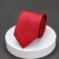 Red checkered tie detail close-up, elegant pattern fabric display on white pedestal. - Red Small Plaid