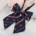 Detailed view of dark blue JK uniform bow tie with red white stripes and embroidery. - Blue Red White Striped Ribbon Bow