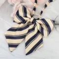 Close-up of classic navy blue and beige striped JK uniform bow tie with ribbon detail. - Bright Yellow Blue Striped Ribbon Bow