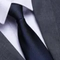 Close-up detail shot of a classic dark blue textured mens business tie with white shirt. - Sea Breeze Blue Zipper Style / 8cm