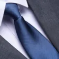 Close-up detail of classic blue textured men's business tie fabric and knot texture. - Ocean Blue Fine Stripe Zipper Style / 8cm