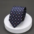 Detailed view of mens dark blue necktie with orange and white floral pattern for business suit. - K25 Yellow Small Flowers