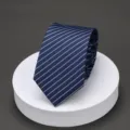 Detailed view of men's blue striped necktie on white podium, perfect for business formal. - LK Blue Stripe