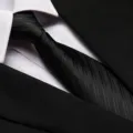 Close-up detail of a classic black business necktie featuring a refined textured pattern. - 8cm Black Bold Stripe Zipper