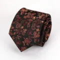 Close-up detail of a vintage black necktie featuring elegant copper floral jacquard pattern. - Black Coffee