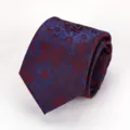 Close-up detail of a retro purple floral patterned necktie with blue and red details. - Fuschia