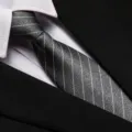Detailed close-up of a stylish striped business tie paired with a crisp white shirt and suit. - 8cm Gray Frosted White Stripe Zipper