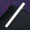 Close-up detail of a sleek silver metallic tie clip featuring subtle engraved stripes for business men. - Tie Clip LDJ106 (Gift Box)
