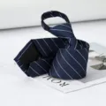 Detailed close-up of a classic navy blue necktie featuring crisp white diagonal stripes. - Diamond Blue Stripe Zipper Style