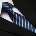 Close-up detail of a classic blue striped necktie paired with white shirt and black suit. - 8cm A02 Zipper