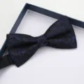 Primo piano dettagliato di un elegante papillon nero con tessuto a fantasia floreale blu tessuta. - Farfallino Fantasia Blu