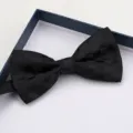 Primo piano del papillon nero a quadri nella scatola, dettaglio formale, tessuto elegante. - Papillon nero a scacchi
