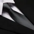 Close-up detail of a classic black business men's tie featuring fine twill texture and neat knot. - 8cm Dark Gray Fine Stripe Zipper