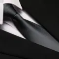 Close-up detail of a classic black business suit tie and collar, smooth woven fabric texture. - 8cm Dark Gray Solid Zipper