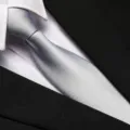 Close-up detail of a classic silver grey men's formal tie paired with white shirt and black suit. - 8cm Silver Solid Zipper